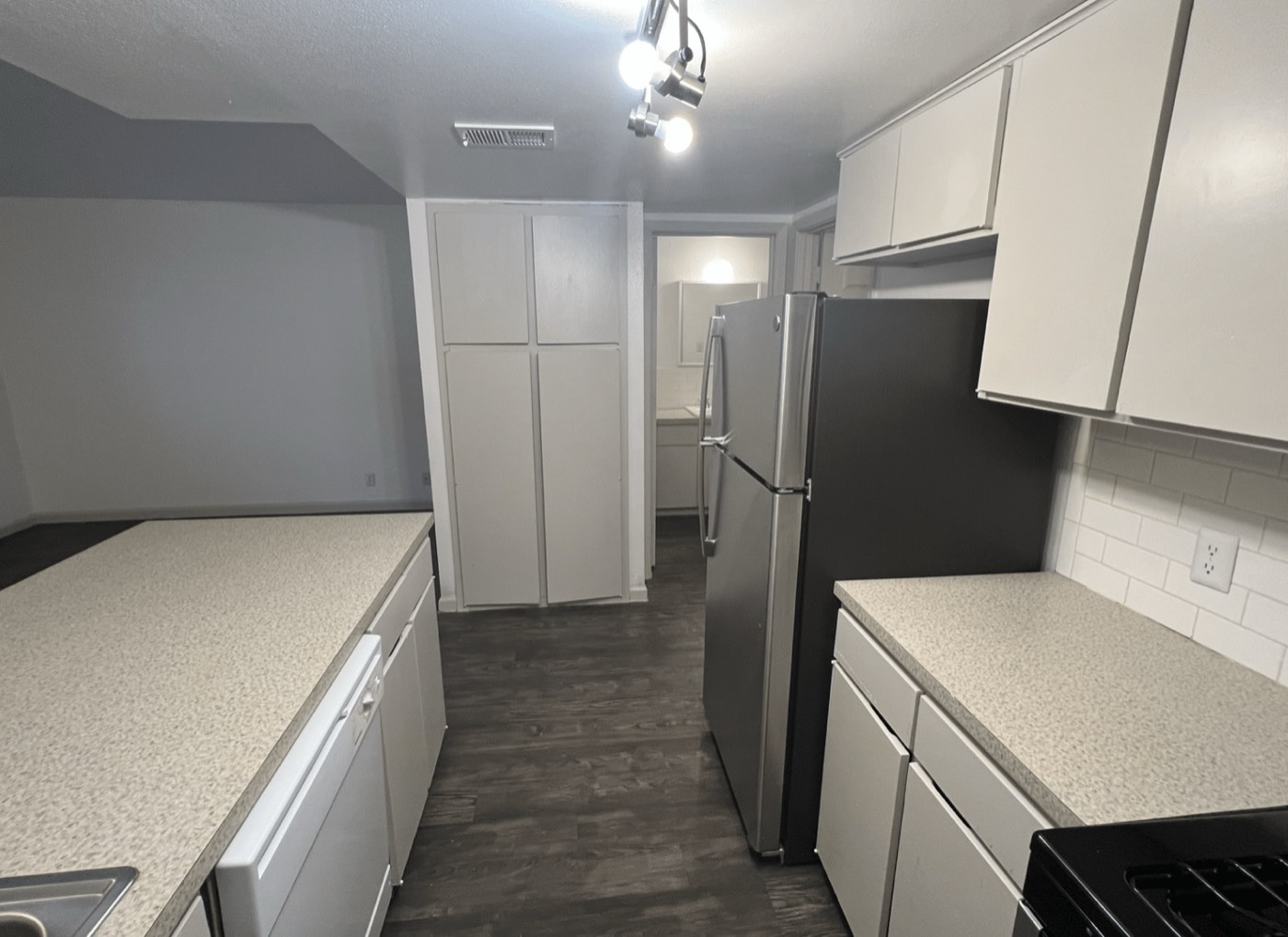 Kitchen with white cabinets and stainless refrigerator